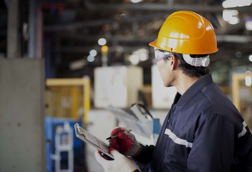 Employee checking manufacturing process review for process safety management