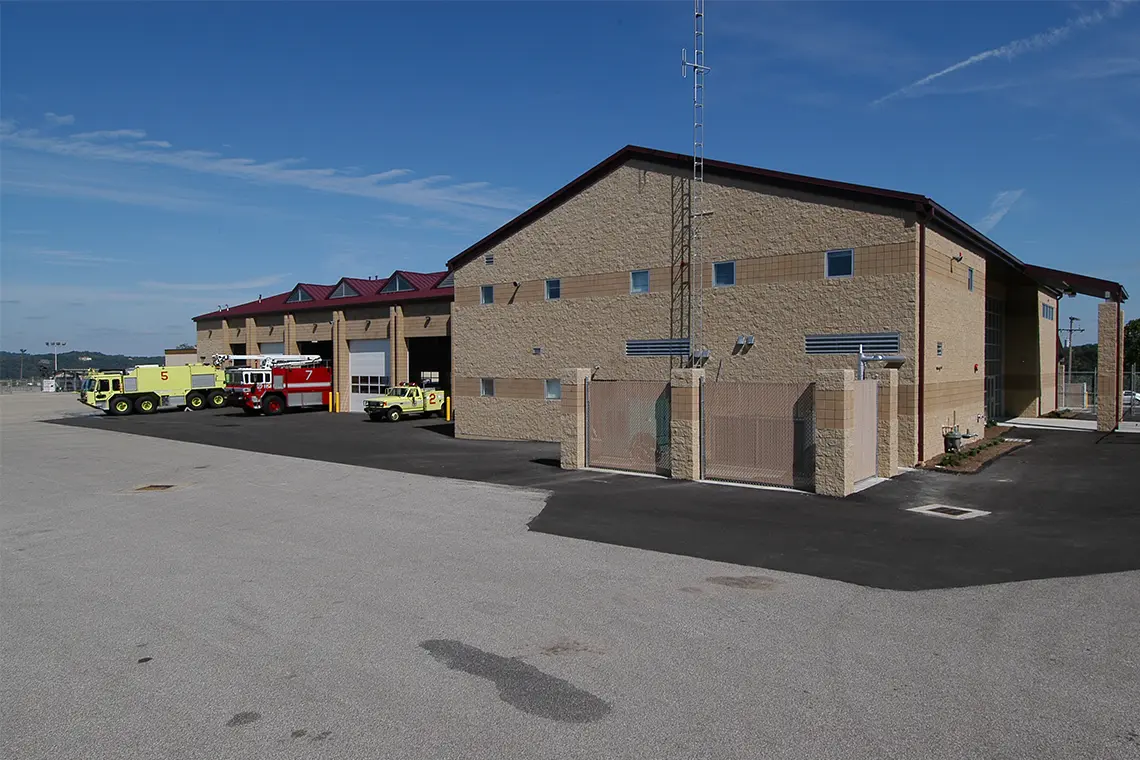 Exterior view of the station and vehicle bays in the background.