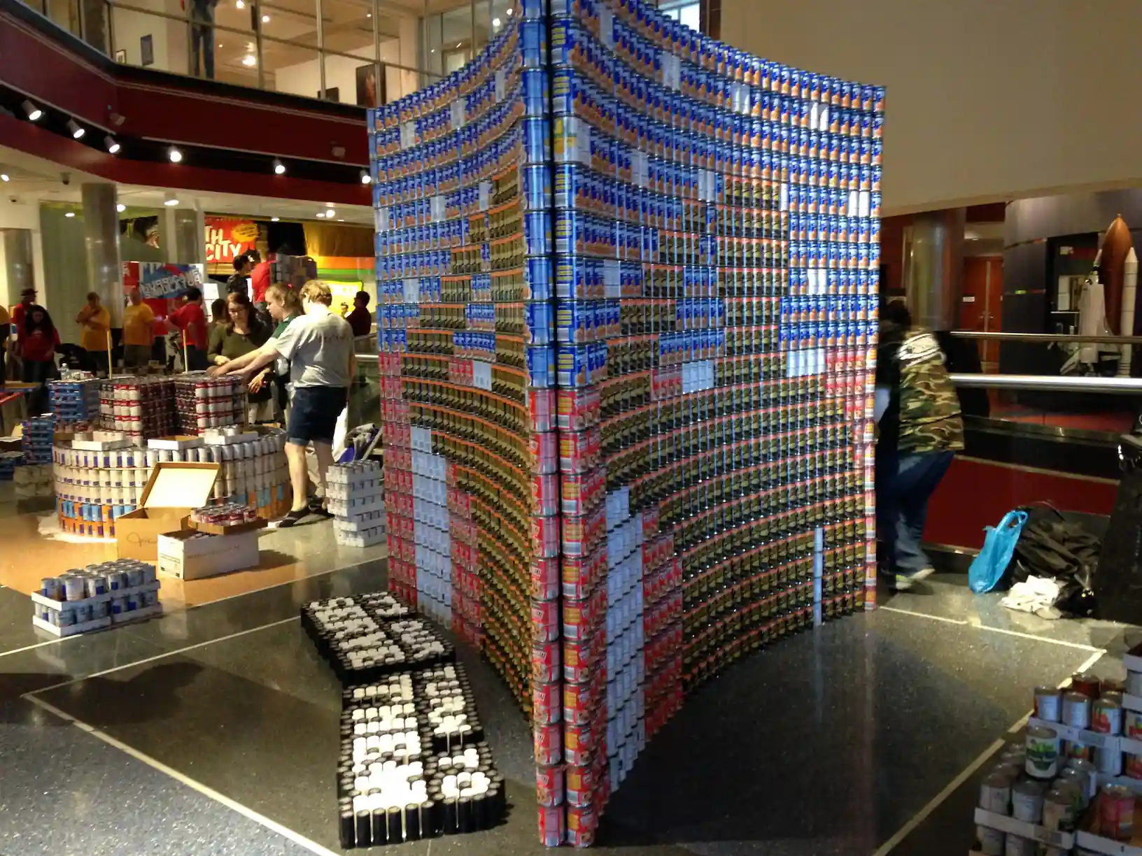 A large, intricate structure built entirely out of canned food